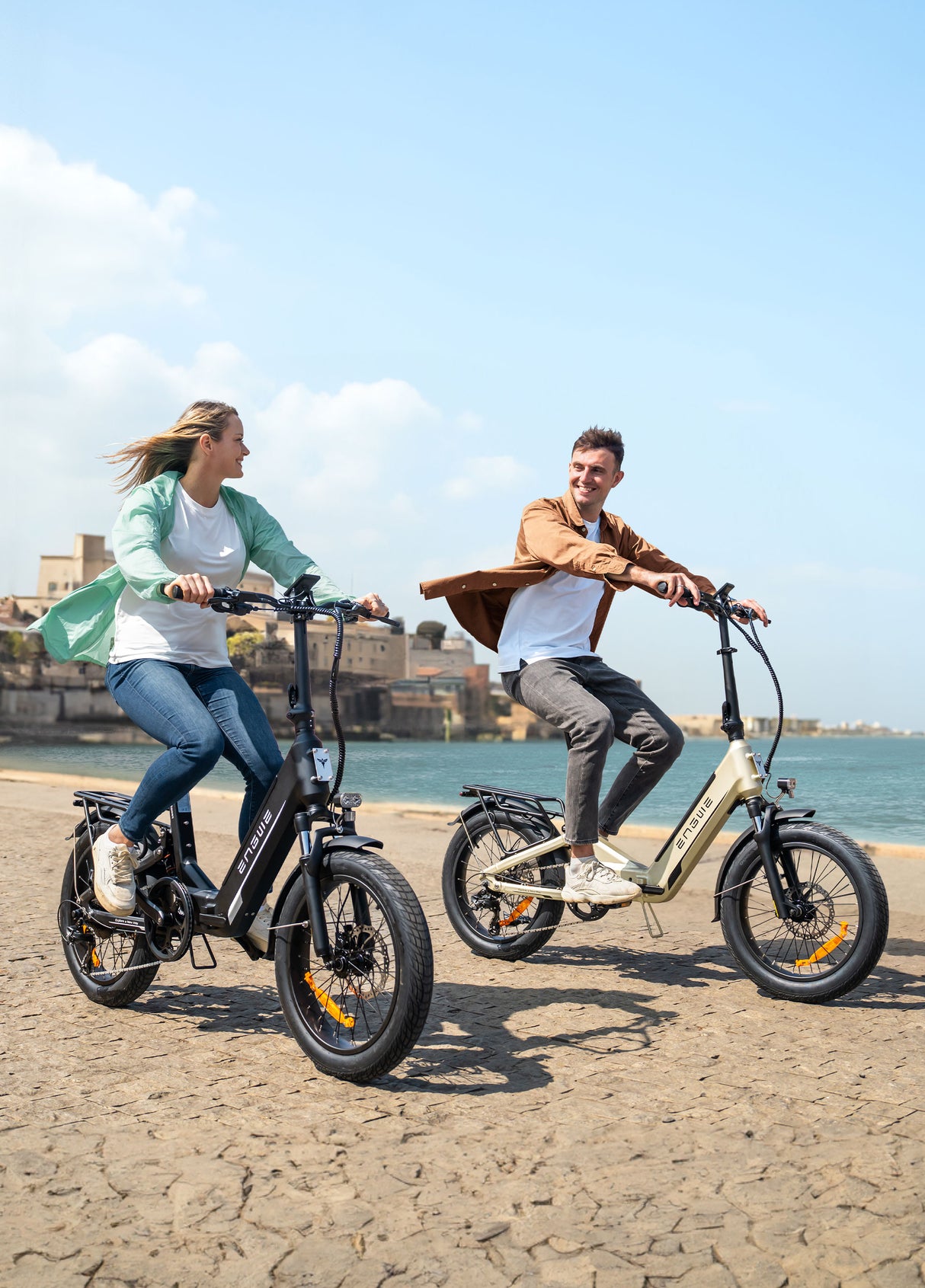two people riding engwe l20 boost folding ebikes on the beach