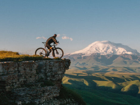 A man sitting on an electric bike in the mountains
