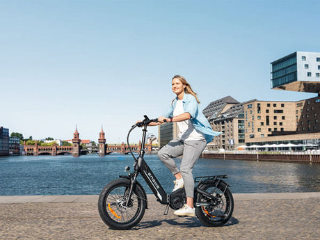 a woman riding a black engwe l20 3.0 pro compact e bike on the road