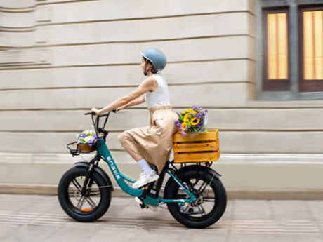 a woman wearing a helmet rides a green engwe l20 boost e-bike on the street