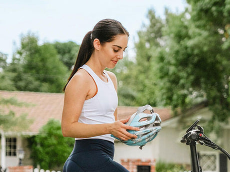 a person sitting on a bike holding a helmet