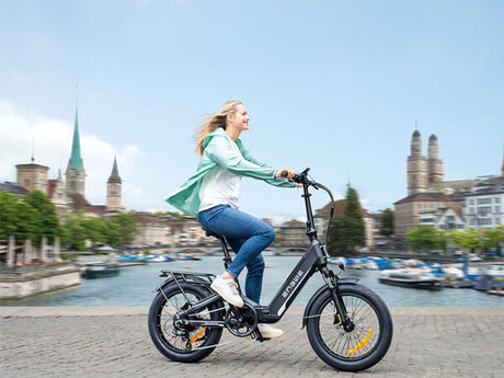 a person riding a black engwe l20 3.0 boost compact electric bike by the river