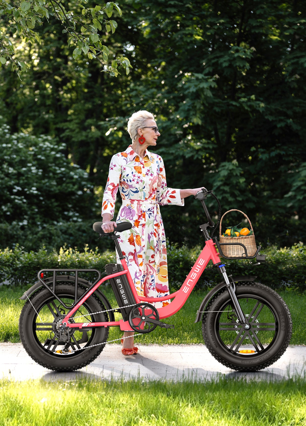 a woman standing next to a flamingo pink engwe l20 e fatbike