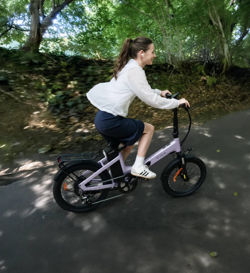 Ciclista utilizando la ENGWE O20 Boost en una ruta urbana arbolada